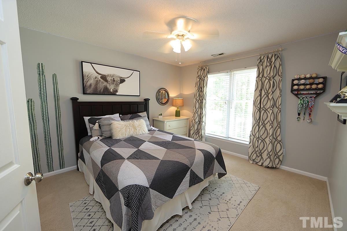 5152 Fairmead Circle Raleigh, NC 27613 - Photo 16 of 25 a bedroom with a bed and a chandelier