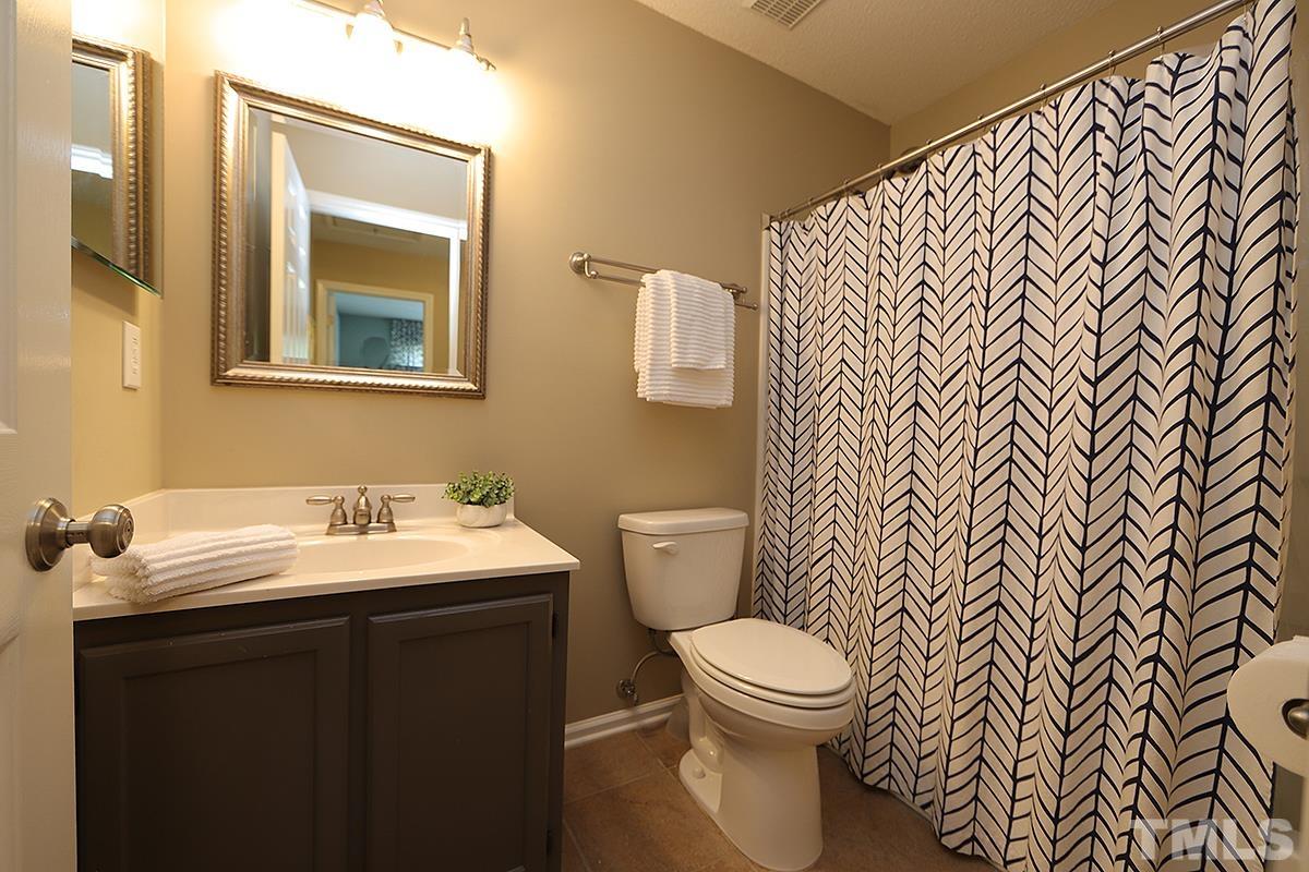 5152 Fairmead Circle Raleigh, NC 27613 - Photo 17 of 25 a bathroom with a toilet a sink and mirror