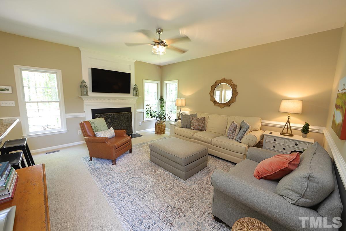 5152 Fairmead Circle Raleigh, NC 27613 - Photo 6 of 25 a living room with furniture a flat screen tv and a fireplace