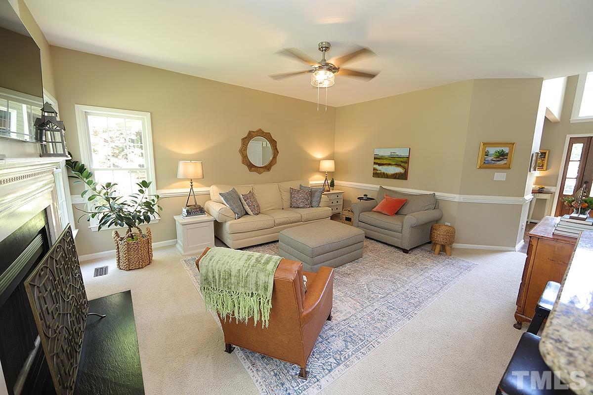 5152 Fairmead Circle Raleigh, NC 27613 - Photo 7 of 25 a living room with furniture a fireplace and a flat screen tv