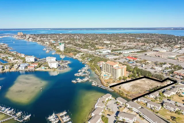 an aerial view of ocean and residential houses with outdoor space