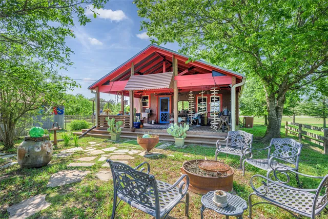 a view of a chair and table in backyard of the house