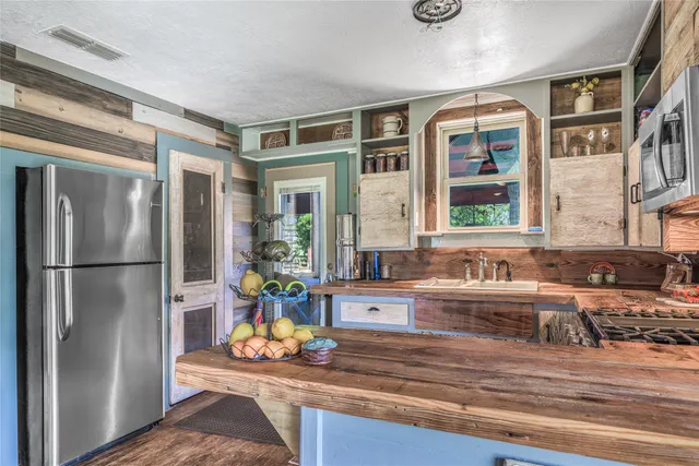 a kitchen with stainless steel appliances granite countertop a refrigerator and a sink