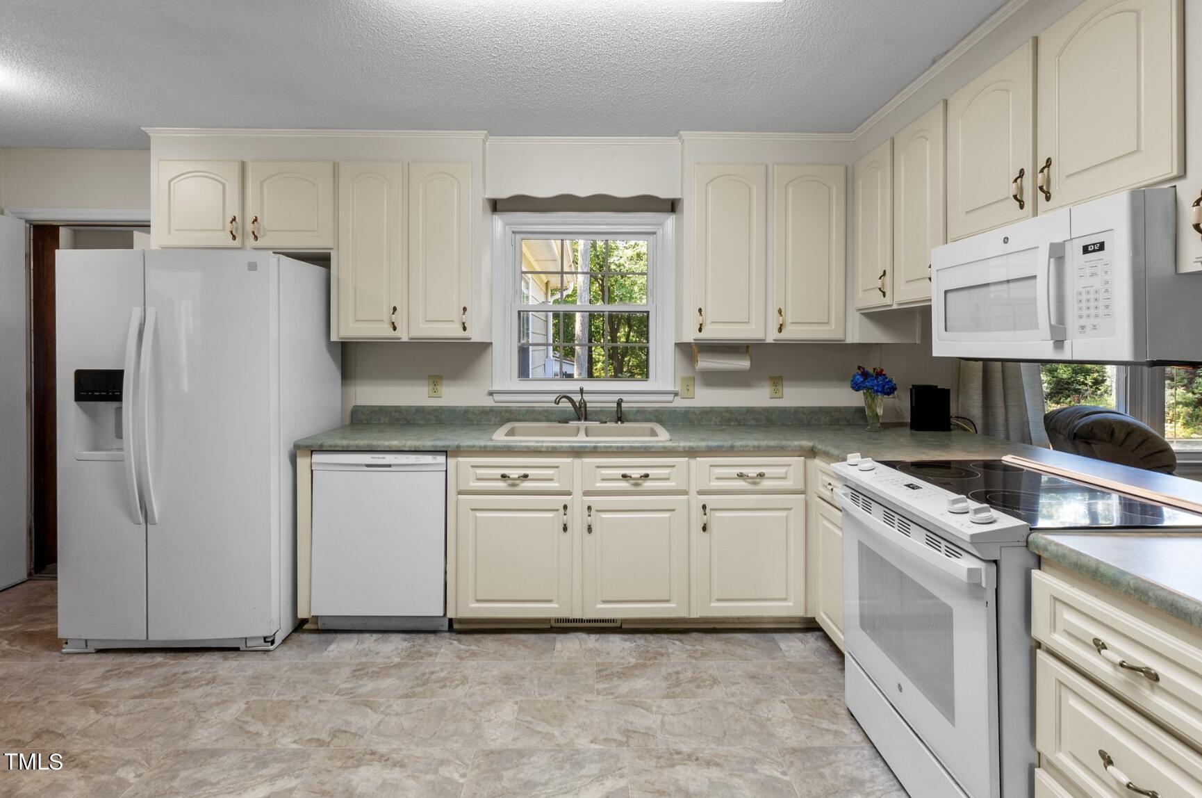 6401 Wrenwood Avenue Raleigh, NC 27607 - Photo 11 of 32 a kitchen with granite countertop white cabinets and white appliances