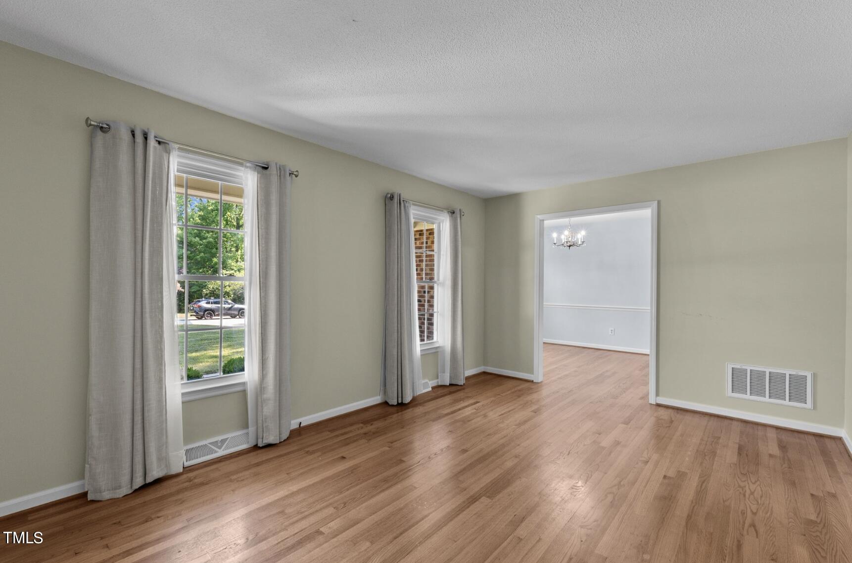 6401 Wrenwood Avenue Raleigh, NC 27607 - Photo 6 of 32 a view of an empty room with wooden floor and a window
