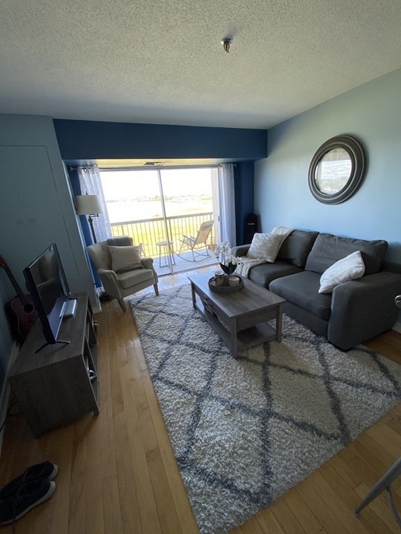 133 Commander Shea Boulevard, Unit 711 Quincy, MA 02171 - Photo 11 of 21 a living room with furniture and a large window