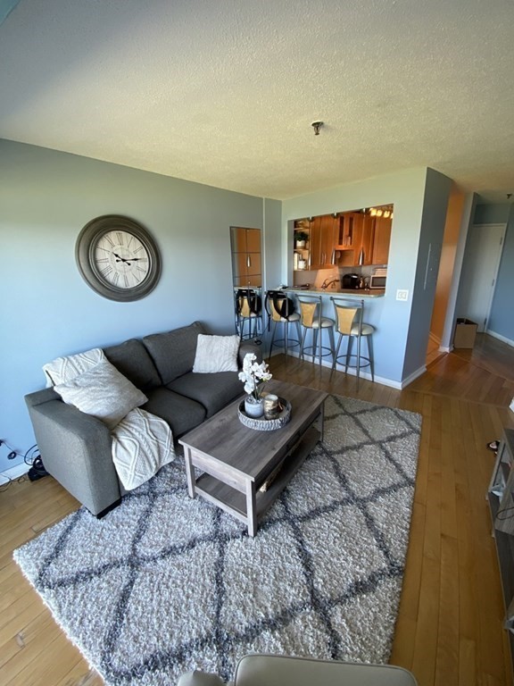 133 Commander Shea Boulevard, Unit 711 Quincy, MA 02171 - Photo 13 of 21 a living room with furniture and a flat screen tv