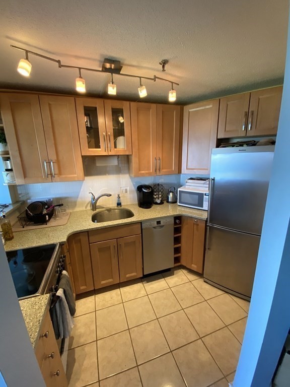 133 Commander Shea Boulevard, Unit 711 Quincy, MA 02171 - Photo 4 of 21 a kitchen with a sink a refrigerator and cabinets