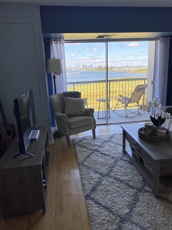 133 Commander Shea Boulevard, Unit 711 Quincy, MA 02171 - Photo 10 of 21 a living room with furniture and a large window