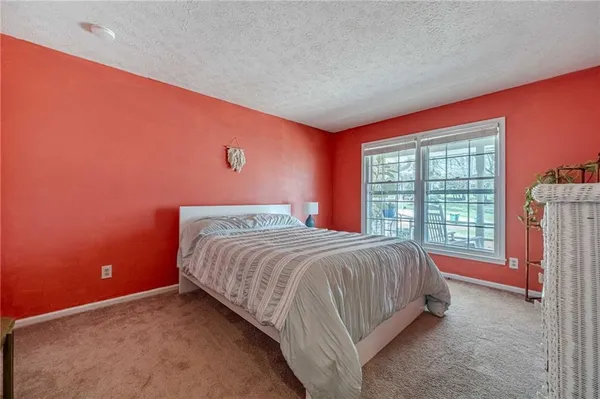 a spacious bedroom with a bed and a flat screen tv