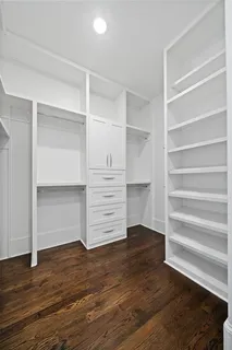 a living room with couches a coffee table and kitchen view with wooden floor