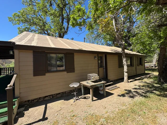 a backyard of a house with table and chairs