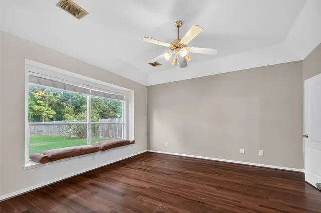a view of an empty room with wooden floor