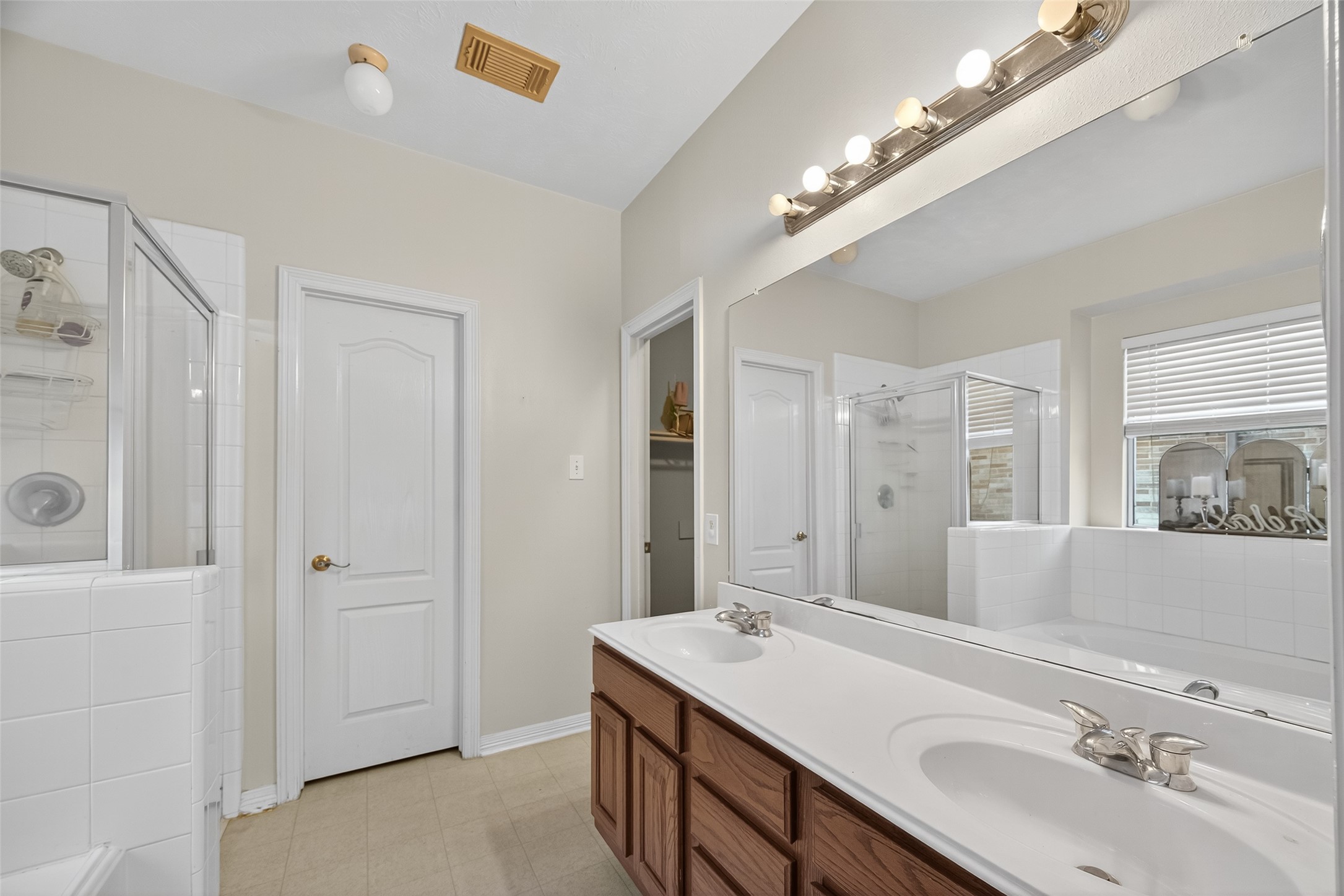 19207 Pinewood Mist Lane Humble, TX 77346 - Photo 15 of 29 a bathroom with a sink double vanity granite tub shower and a mirror