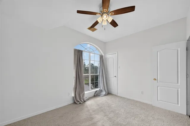 an empty room with chandelier fan