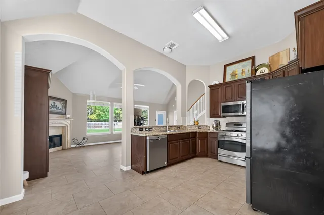 a view of a livingroom with a fireplace a chandelier and windows