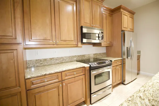 a kitchen with granite countertop white cabinets stainless steel appliances and sink