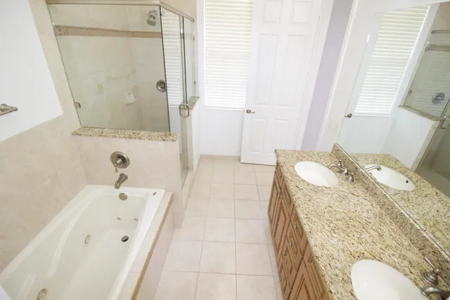a spacious bathroom with a tub sink and mirror