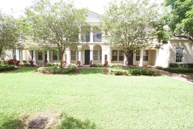 a front view of a house with a yard and trees