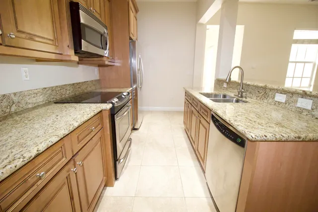 a kitchen with granite countertop sink and cabinets