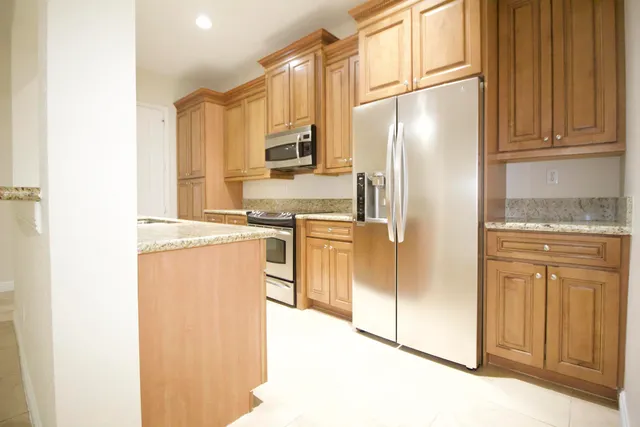 a kitchen with stainless steel appliances granite countertop a refrigerator and a stove