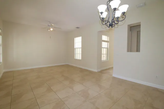 en empty room with windows and chandelier