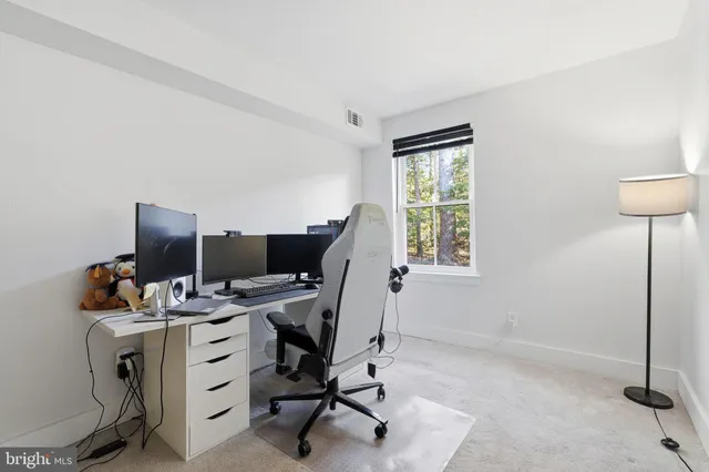 a view of a workspace with furniture and a window