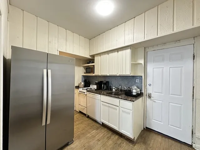 a kitchen with stainless steel appliances a refrigerator a sink and cabinets