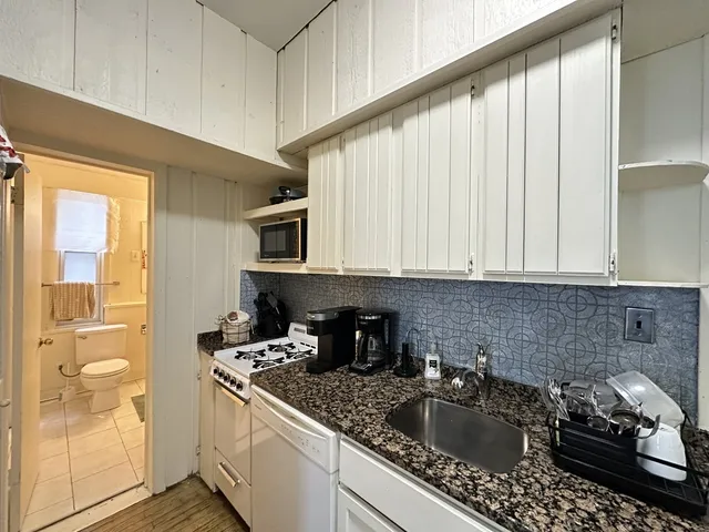 a kitchen with a sink cabinets and a window