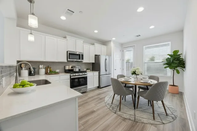 a kitchen with a table chairs stove and cabinets