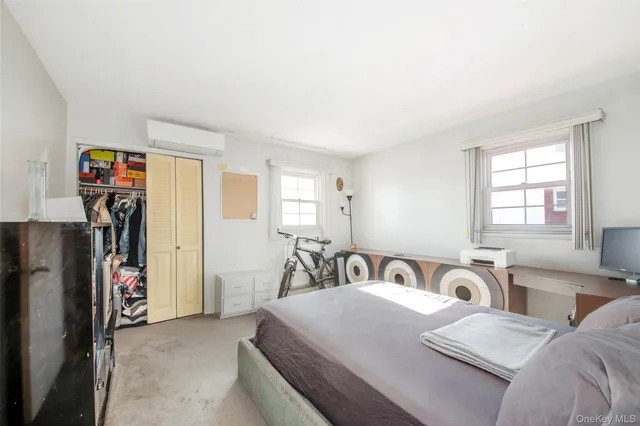 a spacious bedroom with a bed and potted plant