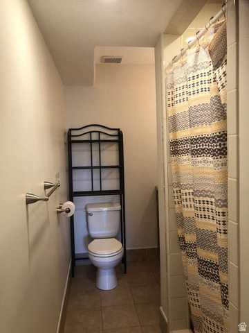 7030 West 2100 North Mendon, UT 84325 - Photo 56 of 67 Bathroom featuring a white toilet, tile flooring, and a shower with white subway tile surround