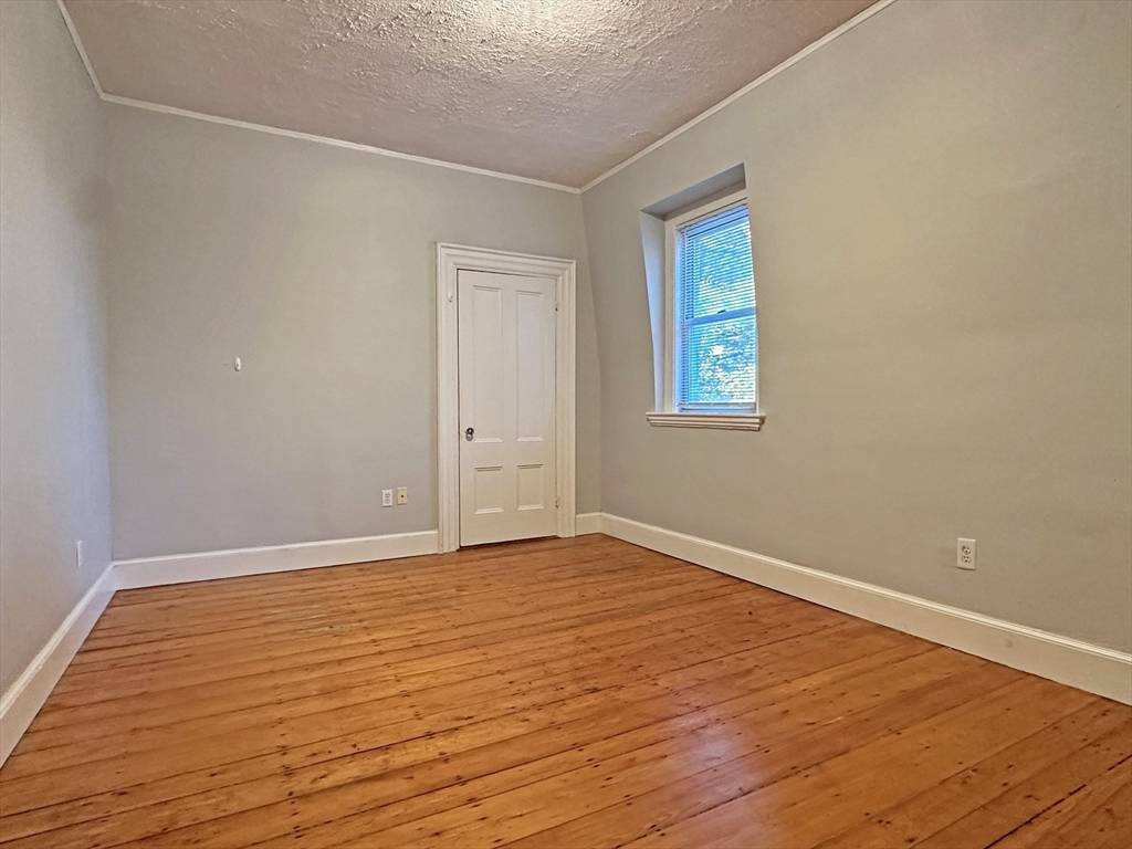 399 Newtonville Avenue, Unit 2 Newton, MA 02460 - Photo 19 of 24 a view of an empty room with wooden floor and a window