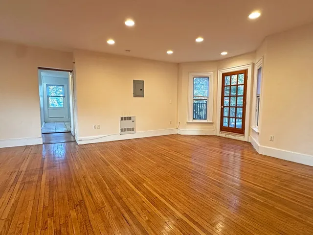 a view of empty room with wooden floor