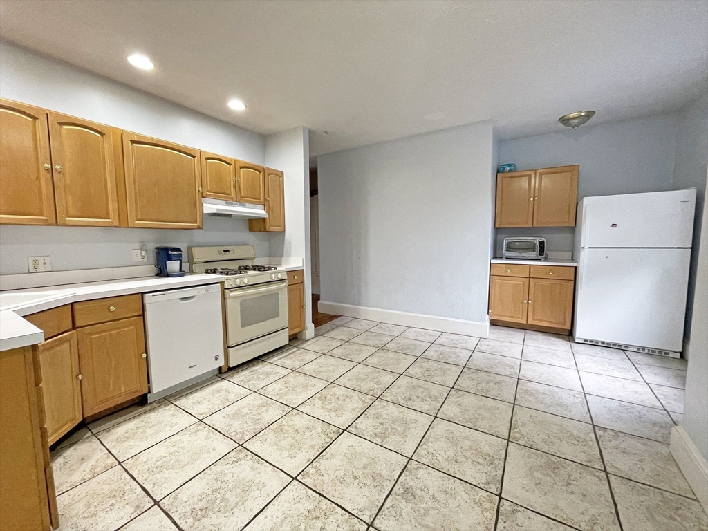 399 Newtonville Avenue, Unit 2 Newton, MA 02460 - Photo 8 of 24 a kitchen with a stove a sink and a refrigerator