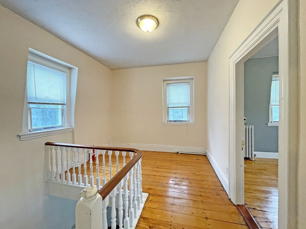 399 Newtonville Avenue, Unit 2 Newton, MA 02460 - Photo 10 of 24 a view of a hallway with wooden floor and staircase