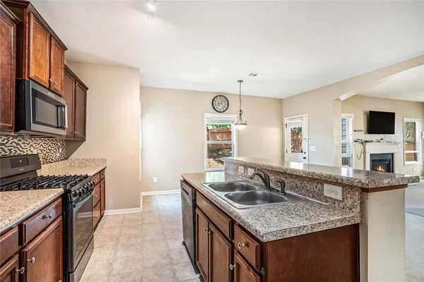 a kitchen with granite countertop a sink stove and cabinets