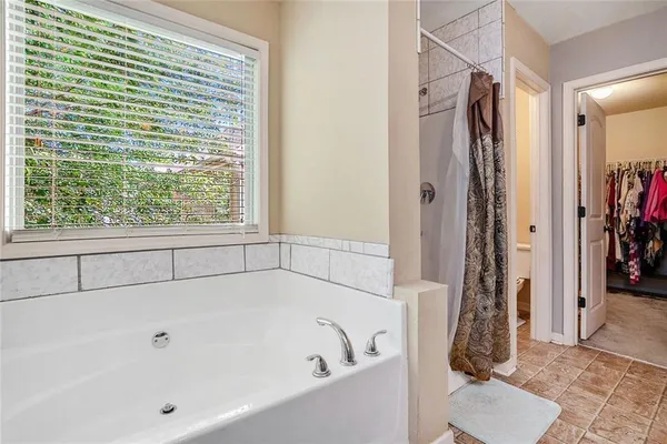 a view of walk in closet with clothes