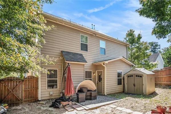 a view of a backyard with a large tree and wooden fence
