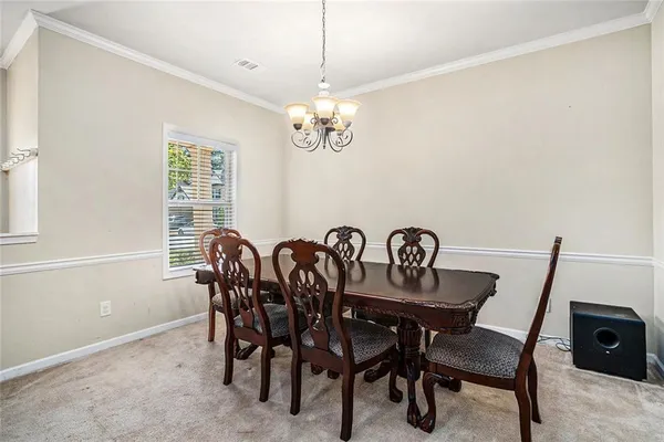 a view of a dining room with furniture and chandelier