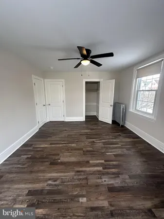a view of empty room with wooden floor and window