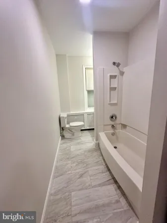 a bathroom with a tub sink and mirror