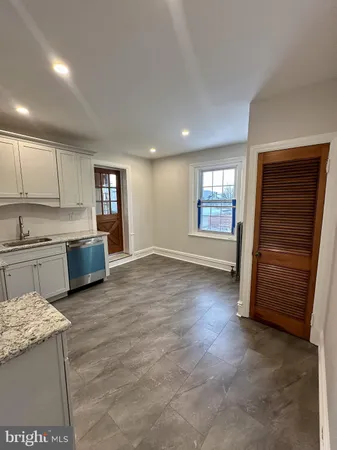 a view of a kitchen with fridge and wooden floor