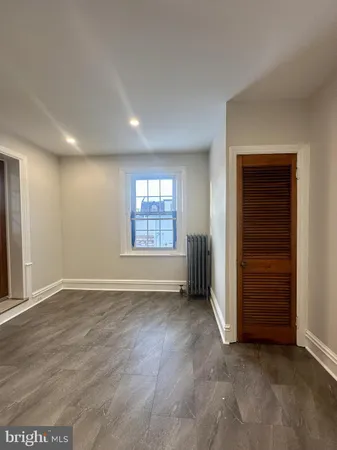 an empty room with closet and windows