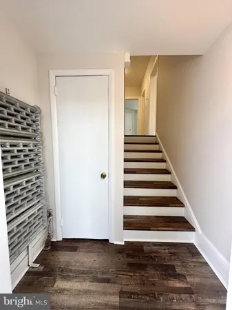 a view of a hallway with wooden floor and white walls