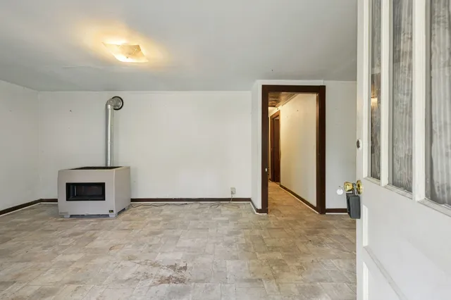 a view of an empty room with a fireplace and a window