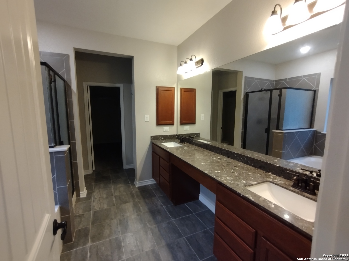 11212 Hill Top Loop Helotes, TX 78023 - Photo 13 of 34 a large bathroom with a granite countertop sink and a large mirror