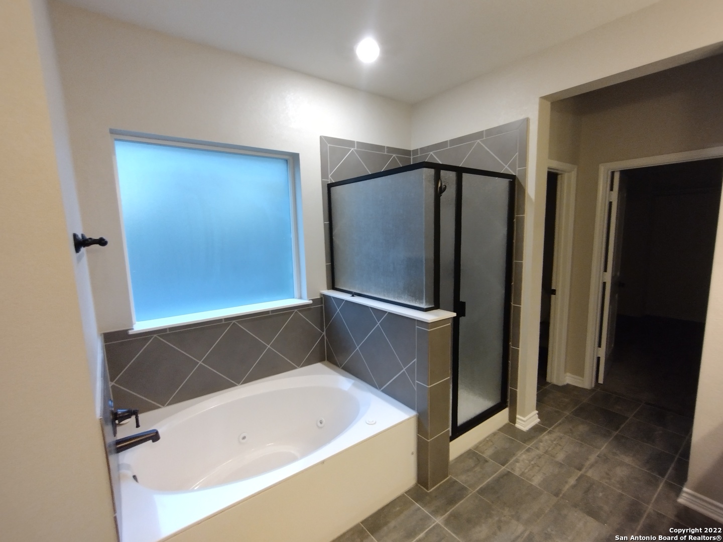 11212 Hill Top Loop Helotes, TX 78023 - Photo 14 of 34 a bathroom with a tub and a shower