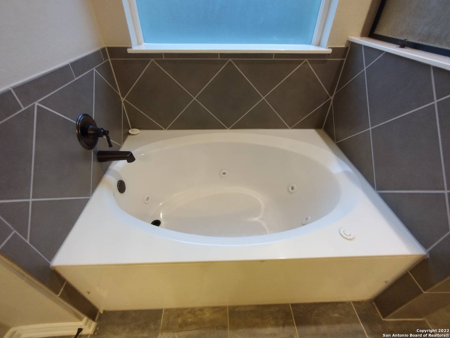 11212 Hill Top Loop Helotes, TX 78023 - Photo 15 of 34 a bathroom with a bathtub