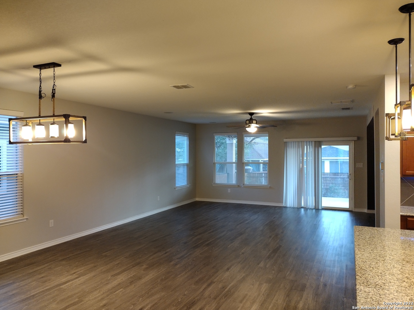 11212 Hill Top Loop Helotes, TX 78023 - Photo 5 of 34 an empty room with wooden floor and windows